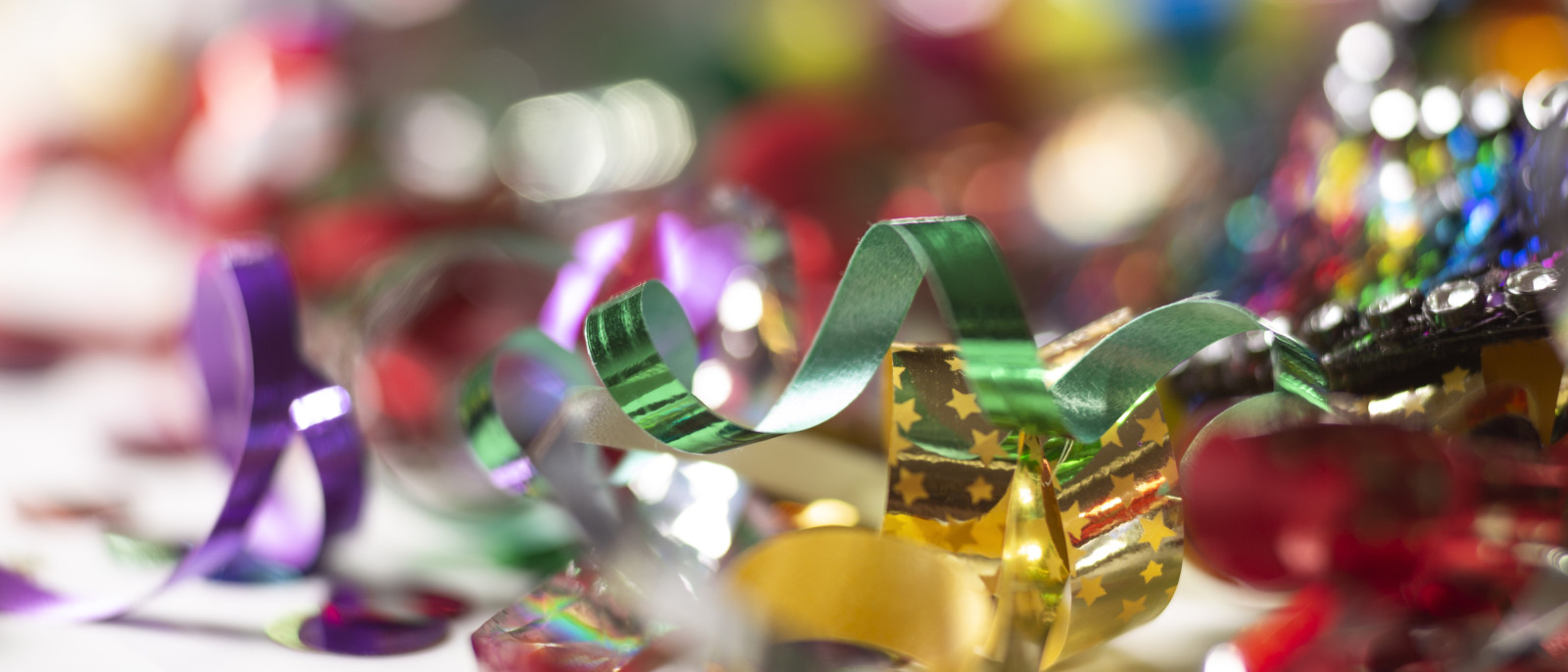 Farbiges Konfetti und Bänder auf einer Oberfläche, Nahaufnahme.