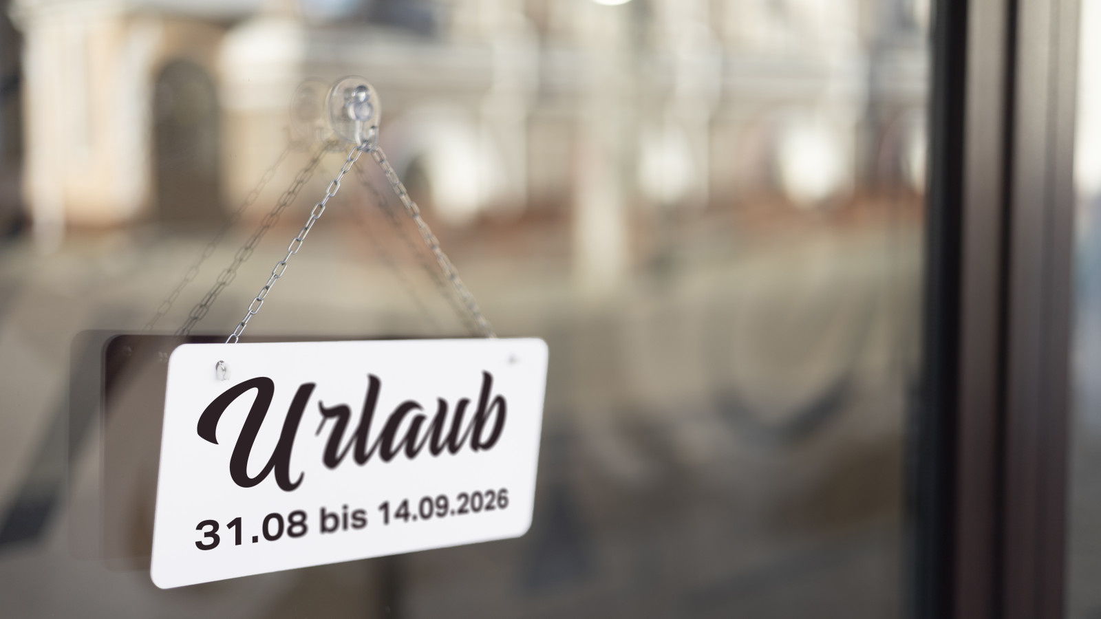 Urlaubsschild an einer Glastür mit Daten 31.08 bis 14.09.2026.